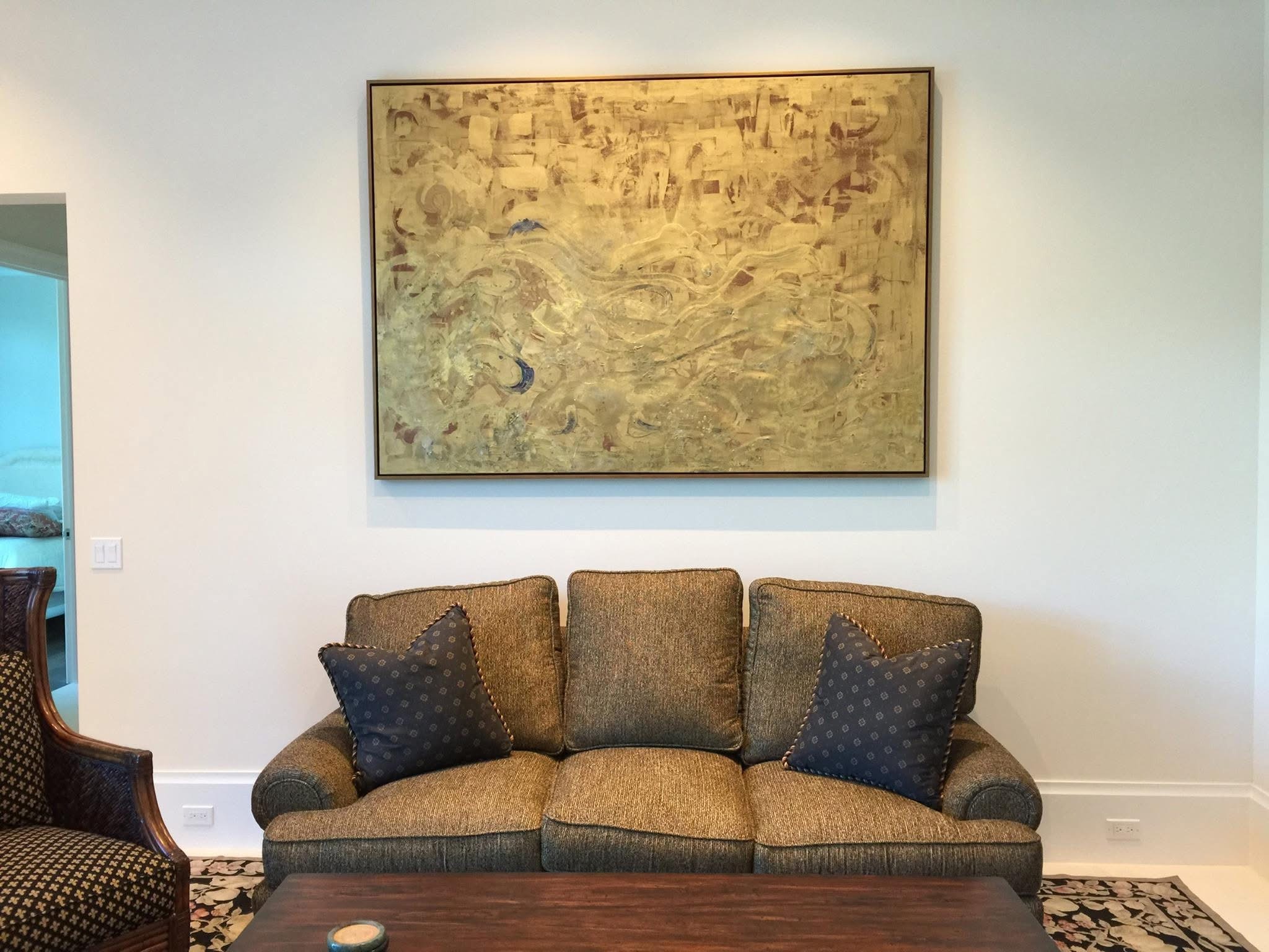 Now & Never, gold painting by Sarah Edgehill, hanging above a sofa
